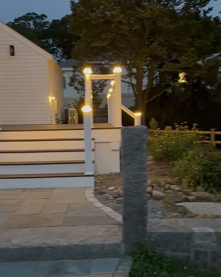 Outdoor deck step and post lighting installed at dusk